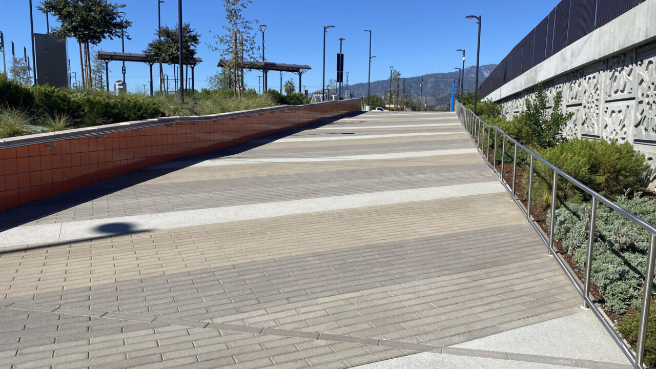 Transit station with paver walkways in a modern outdoor setting.