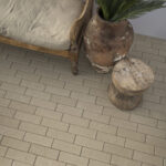 Wooden bench with cushion beside a weathered terracotta urn planted with greenery, on a tan quarter runner paver floor.